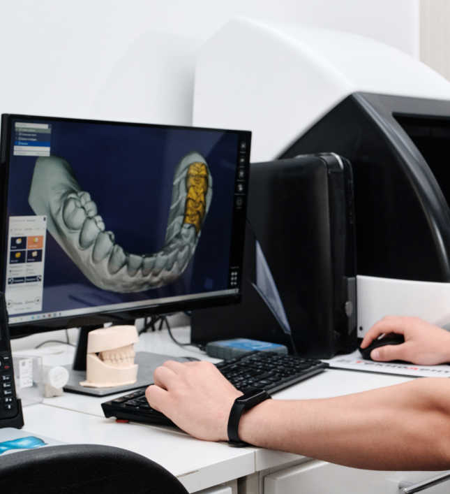 Dental technician using 3D software to design custom veneers.