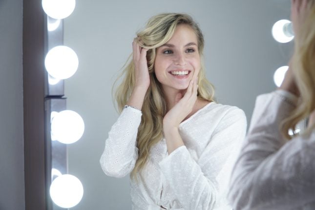Client admiring her whiter smile in the mirror.